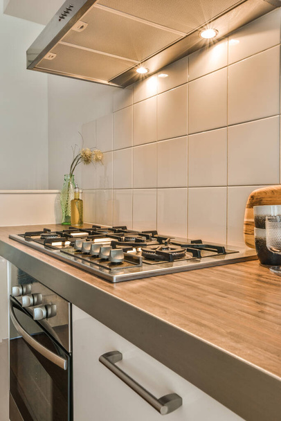 kuchyň s bílými dlaždicemi a dřevěnými deskami na sporáku, která byla použita jako spotřebič pro vaření - Fotografie, Obrázek