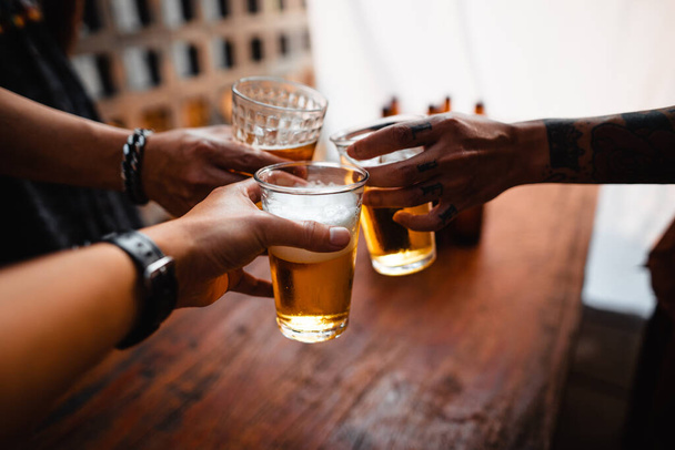 Группа счастливых друзей, пьющих и пьющих пиво в ресторане пивоварни-бара
 - Фото, изображение