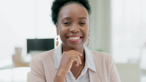 Feliz, cara y mujer de negocios en su oficina con confianza, liderazgo y una mentalidad positiva. Felicidad, sonrisa y retrato de una empleada africana profesional sentada junto a su escritorio en el lugar de trabajo. - Metraje, vídeo