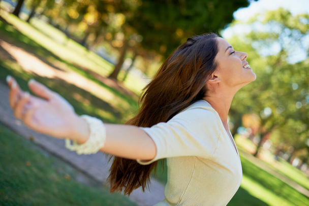 Het beste gevoel in de wereld. een zorgeloze jonge vrouw geniet van een dag in het park - Foto, afbeelding