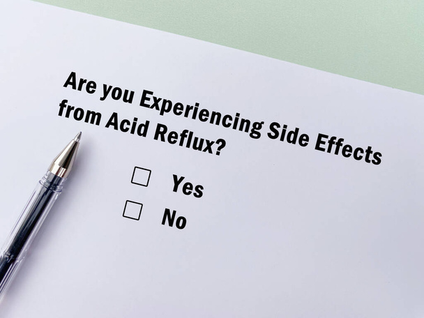 One person is answering question about side effects. She is experiencing side effects of acid reflux. - Fotó, kép