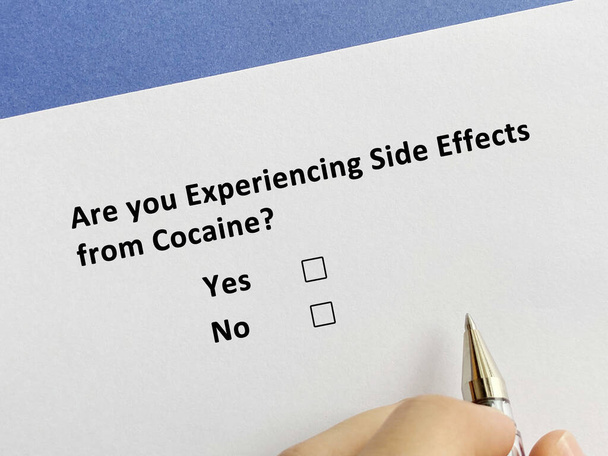 Una persona está respondiendo a una pregunta sobre los efectos secundarios. Está experimentando efectos secundarios de la cocaína.. - Foto, Imagen