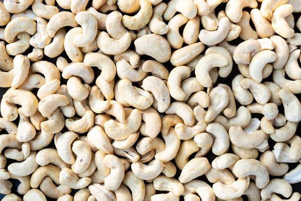 Raw cashew nuts on a wooden table close-up. - Photo, Image