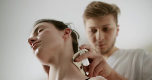 IASTM, миофасциальное освобождение от ромбов и боли с помощью умных инструментов, терапевт, использующий инструмент IASTM для лечения боли в лопатке, выполняя операции по освобождению фасции мягких тканей на шее  - Кадры, видео