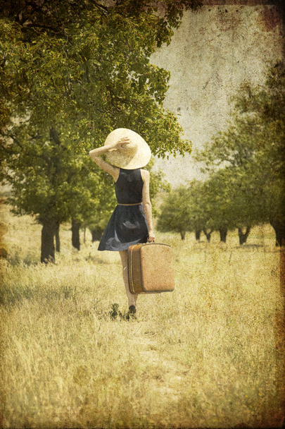 κοκκινομάλλα κοπέλα με βαλίτσα σε χώρα. - Φωτογραφία, εικόνα