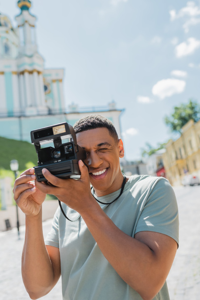 vidám afro-amerikai turista fotózás vintage kamera Andrews származás Kijevben, Ukrajna - Fotó, kép