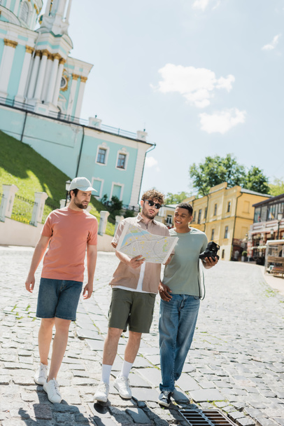 volle Länge der multikulturellen Touristen zu Fuß in der Nähe Reiseleiter mit Stadtplan auf Andrews Abstieg in Kiew - Foto, Bild
