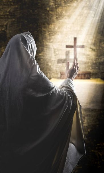person praying in a cassock with a crucifix in front of him - 写真・画像