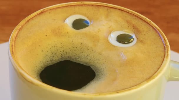 Großaufnahme Kaffeetasse mit Augen und Mund schreit sehr laut. Emoji-Kaffee. Heitere Stimmung beim Barista, der Kaffee mit menschlichem Antlitz kochte. Hochwertiges 4k Filmmaterial - Filmmaterial, Video