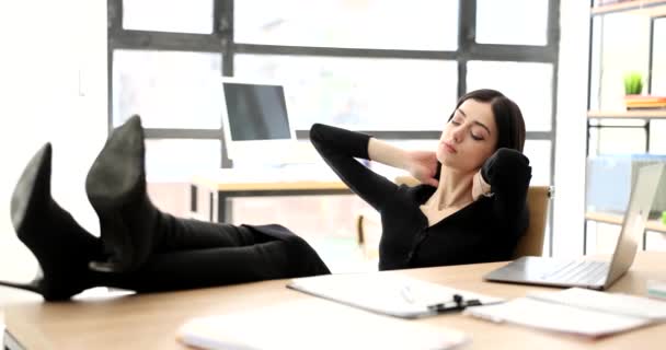 Fáradt üzletasszony pihen a munkahelyén a lábával a 4K asztalnál, lassított felvételen. Unalmas munkahely - Felvétel, videó