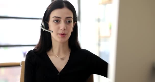マイクを持つヘッドフォンの女性は、クライアント4kムービーに話しています。コールセンターの運営者としての業務 - 映像、動画