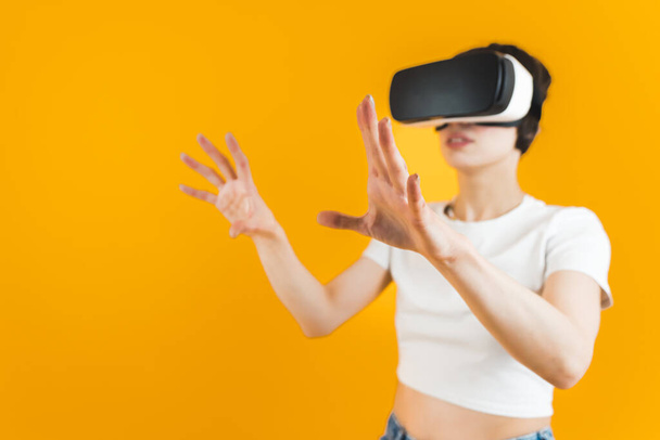 A nő felemeli a kezét egy VR fejhallgatóval. Közepes lövés. Fényes háttér. Kiváló minőségű fénykép - Fotó, kép
