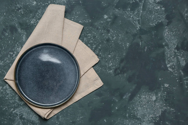 Plate with clean napkin on dark color background - Foto, Imagem