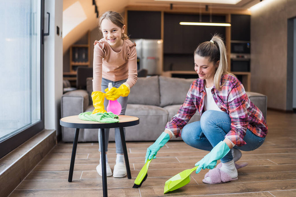 Happy mother and daughter cleaning house together. - Φωτογραφία, εικόνα