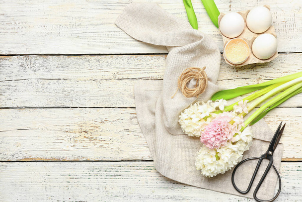 Composizione con fiori di giacinto, uova di Pasqua, filo e forbici su fondo di legno bianco - Foto, immagini