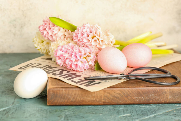 Bellissimi fiori di giacinto, uova di Pasqua e forbici sul tavolo vicino alla parete beige - Foto, immagini