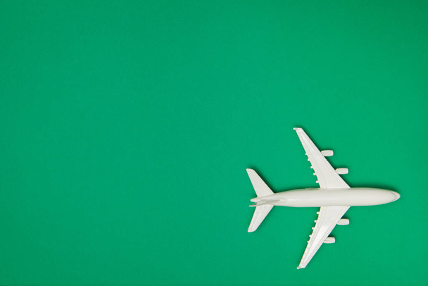 Airplane model. White plane on green background. Travel vacation concept. Summer background. Flat lay, top view, copy space. - Фото, зображення