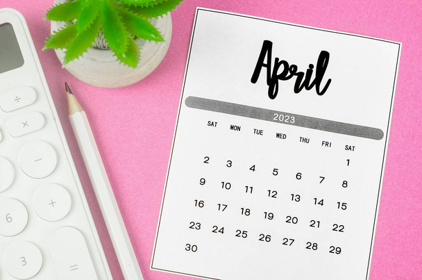 April 2023 Monthly calendar for 2023 year with calculator on pink background. - Foto, afbeelding