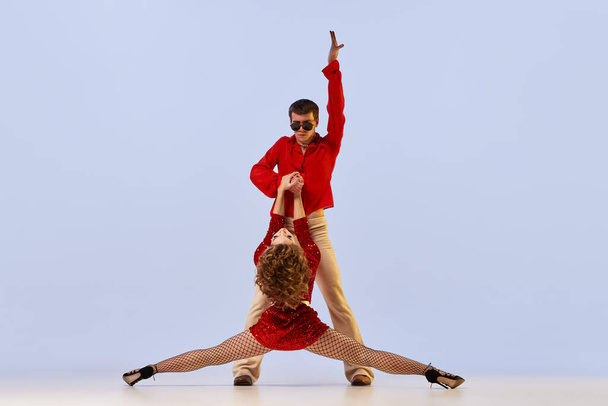 Namiętność. Młoda elastyczna para tancerzy w jasnych kostiumach scenicznych tańczących na jasnym tle. Koncepcja emocji, akcji, ruchu, muzyki, sztuki, tańca, reklamy - Zdjęcie, obraz