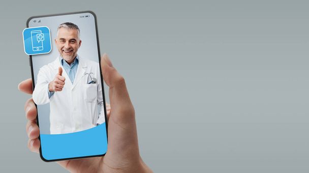 Online medical service and telemedicine: doctor giving advice on smartphone screen - Fotó, kép