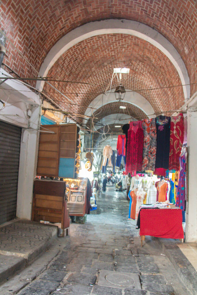 Commerce dans l'ancienne Médina de Tunis en Tunisie. Des vêtements vendus pour les touristes. Vêtements traditionnels.  - Photo, image