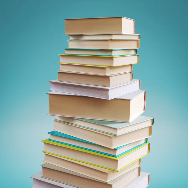 Many stacked books on blue background, learning and reading concept - Фото, изображение
