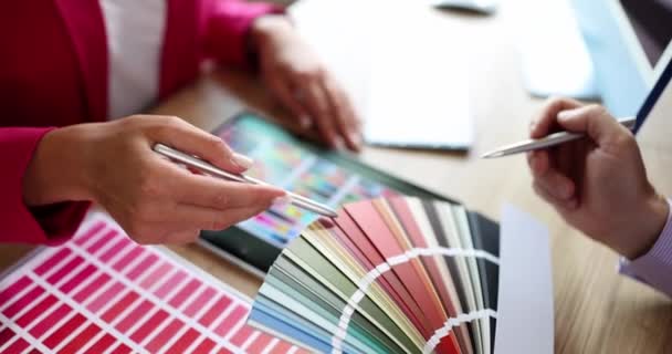 Designer aconselha o cliente e mostra a amostra de cor na paleta de cores e no tablet. Seleção de cores interiores apresenta uma seleção de cores e amostras de tinta - Filmagem, Vídeo