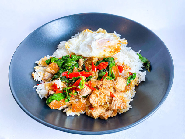 Riso condito con pancetta di maiale croccante con basilico tailandese e uovo fritto - Foto, immagini