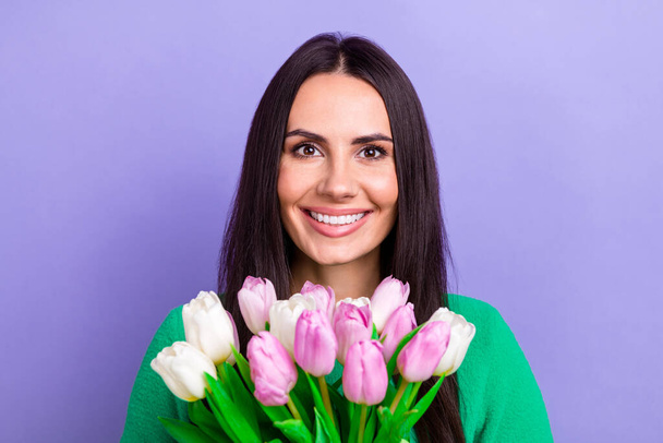 Photo of shiny adorable lady dressed green sweater smiling holding tulips bunch isolated violet color background. - Φωτογραφία, εικόνα