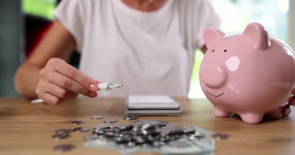 Varkensbank met vork, bankbiljetten en munten. Online bankieren en sparen. Het concept van energiebesparing en -besparing gezinsbudget - Video
