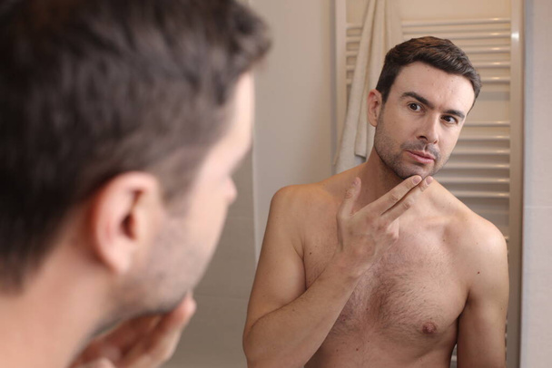 retrato de joven guapo delante del espejo en el baño - Foto, imagen