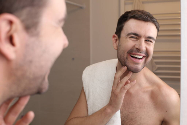 portrait of handsome young man in front of mirror in bathroom - Zdjęcie, obraz