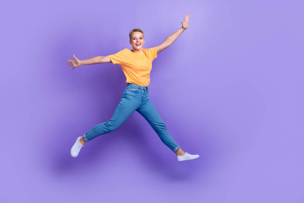 Full body portrait of overjoyed sportive lady jumping raise hands good mood isolated on purple color background. - Photo, image