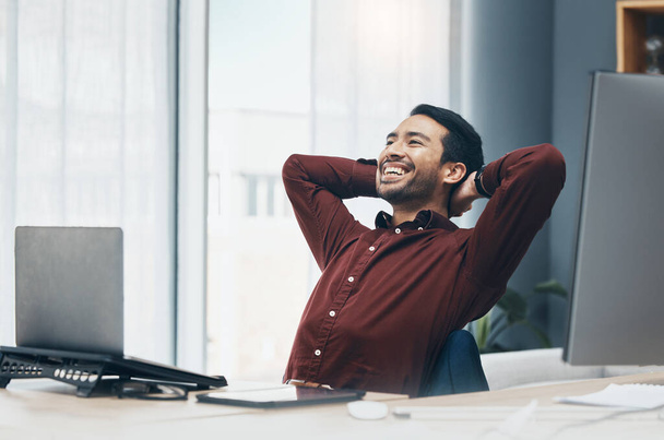 Mosoly, pihenés és üzletember az irodában befejezése után projekt vagy feladat a munkahelyen. Nevetés, gondolkodás és boldog férfi szakmai pihenés vagy pihenés befejezése után a munka, célok és célok - Fotó, kép
