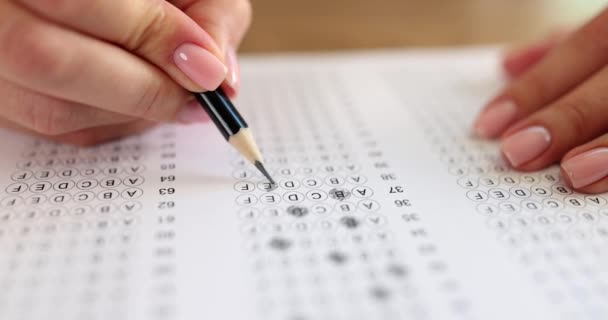 Examen de la mano del estudiante en un examen con lápiz. Personas seleccionadas en una hoja de respuestas para los exámenes finales de secundaria en la universidad o la universidad - Metraje, vídeo
