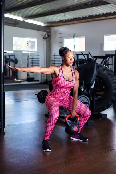 Determined Woman Doing Squat Exercises With Kettlebell. Spine strengthening. - Foto, Imagen
