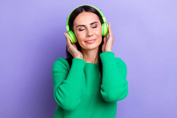 Photo of sweet charming woman wear green pullover closed eyes enjoying good music isolated purple color background. - Фото, изображение