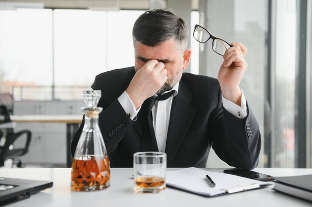 Old businessman drinking from stress - Photo, Image