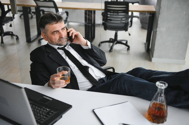 Old businessman drinking from stress - Фото, зображення