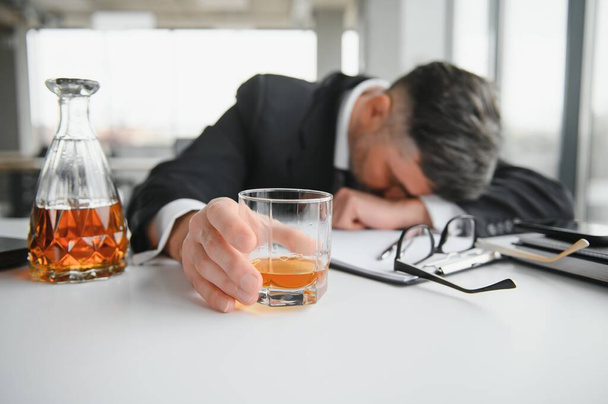 Alcoholism at work. Tired employee drinking alcohol at workplace, can not handle stress. - Foto, immagini