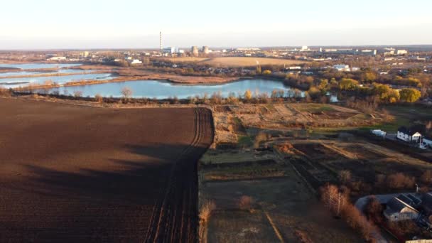 Urban beautiful landscape agricultural plowed fields, lakes for growing fish, gardens, thermal power plant, building industrial area of city on a sunny autumn day. Aerial drone view. Agrarian scenery - Footage, Video