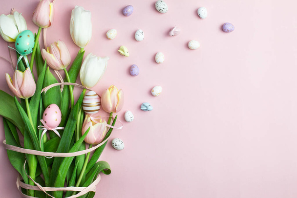 Wielkanocna kompozycja różowych i białych tulipanów, wstążki, ślicznych króliczków i dekoracyjnych jaj na różowym tle. Bukiet tulipanów, wiosenne kwiaty. Zawartość na Wielkanoc. Płaskie ułożenie, widok z góry, zbliżenie, przestrzeń do kopiowania - Zdjęcie, obraz