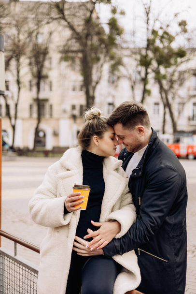 Feliz joven pareja enamorada en ropa interior caminando por la calle y tomando café. Recreación al aire libre. Una joven pareja casada - Foto, imagen