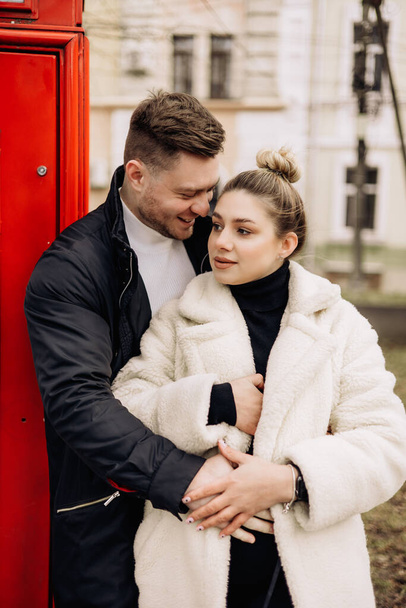 Una linda pareja enamorada en ropa de abrigo está caminando por la calle en primavera. Recreación juntos al aire libre. Joven pareja elegante. - Foto, imagen