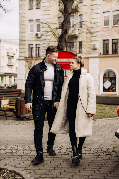 Um casal bonito apaixonado em outerwear está andando na rua na primavera. Recreação juntos ao ar livre. Jovem casal elegante. - Foto, Imagem