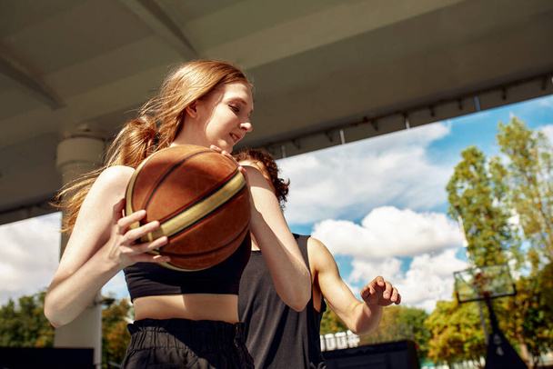 Vielfalt, Freunde haben eine aktive Erholung durch Streetball, Basketball auf dem städtischen Spielplatz, aktiver Zeitvertreib, Sportspiele in der städtischen Umgebung - Foto, Bild