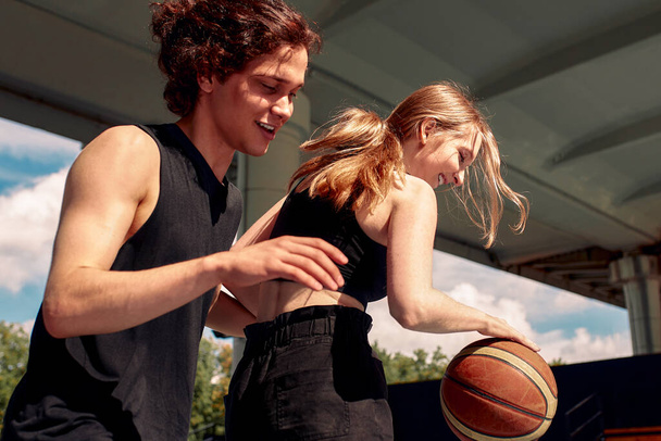 Közelkép a fiatalok kosárlabdáznak, fiúk és lányok kosaraznak egy napsütéses napon, aktívan töltik az időt. - Fotó, kép