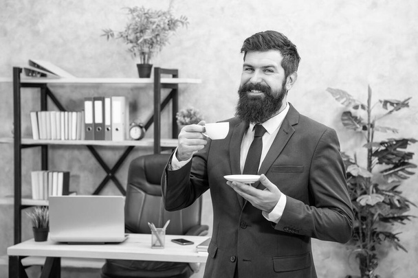 happy bearded businessman drinking coffee in the office with copy space, morning. - Fotó, kép