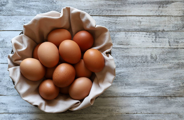 Huevos de pollo aislados sobre un fondo de madera. Vista desde arriba, copiar espacio. Concepto de comida saludable. Vacaciones de Pascua. - Foto, Imagen