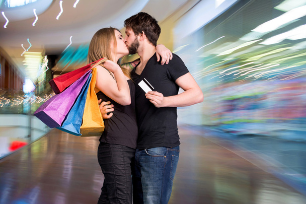 Feliz pareja de besos con bolsas de compras
 - Foto, imagen